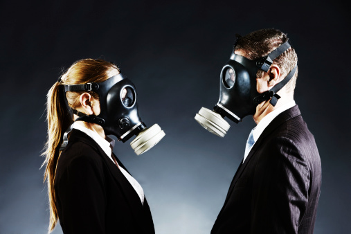 Couple in gas masks face off confronting each other