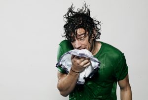 Man standing in rain, Sneezing.